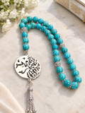 Turquoise-colored prayer beads with a nickel pendant.